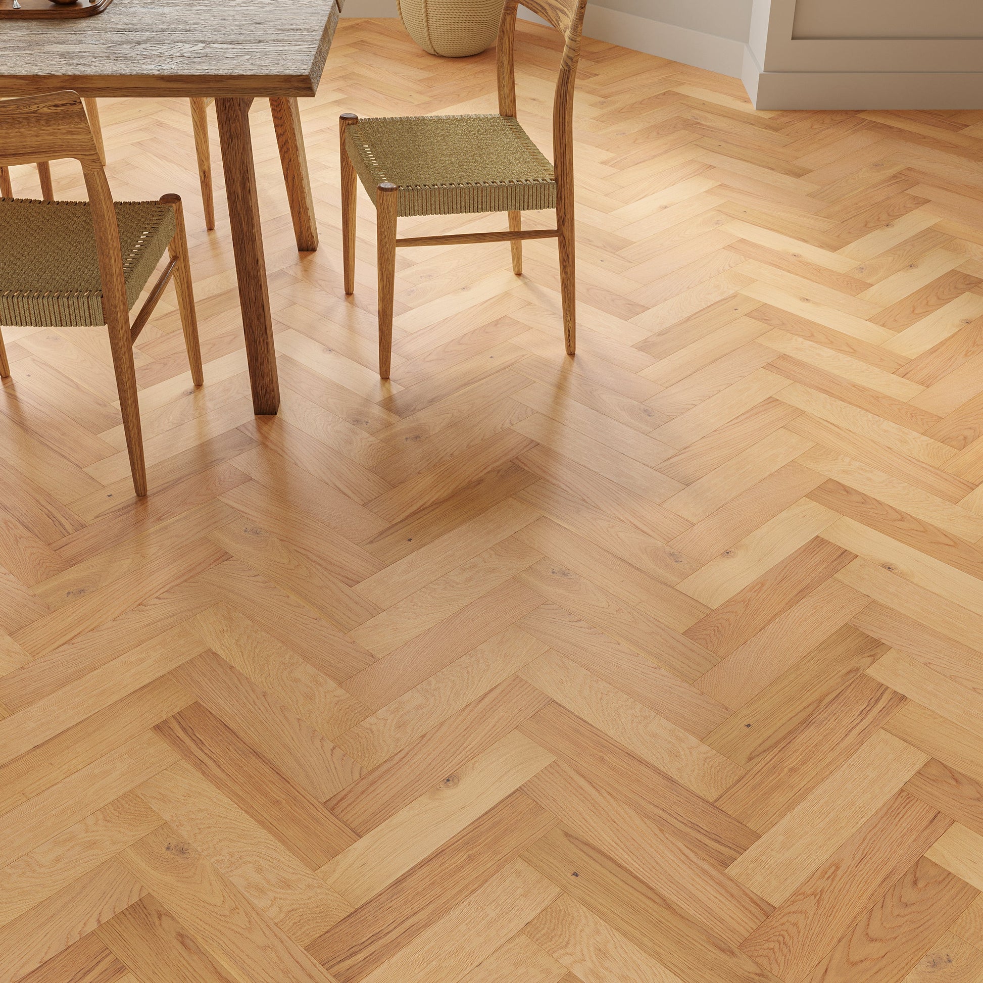 Wooden floor with a herringbone pattern in a room with chairs and a table.
