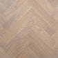 Close-up of a wooden floor with a herringbone pattern